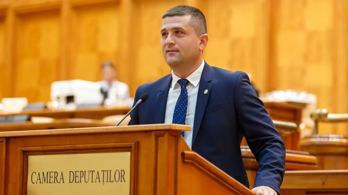Radu Miruță la tribuna Camerei Deputaților, în fața unui microfon.