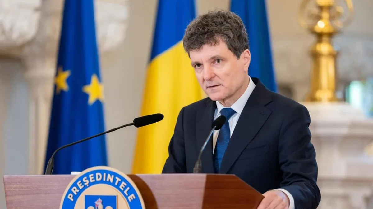 Nicușor Dan la pupitrul prezidențial, între două microfoane, cu drapelele României și Uniunii Europene în fundal.